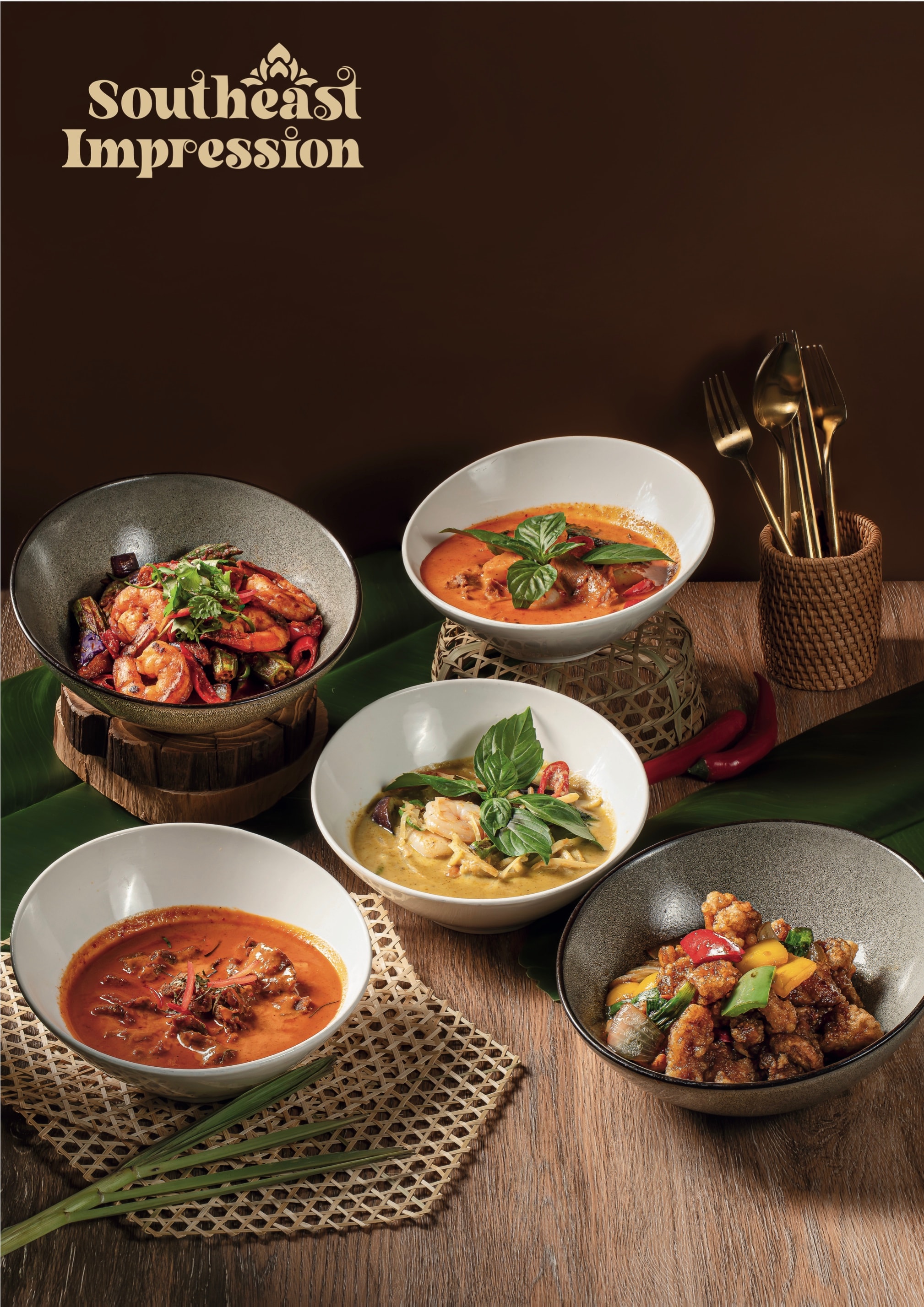 Panang and green curry served in dark ceramic bowls with basil